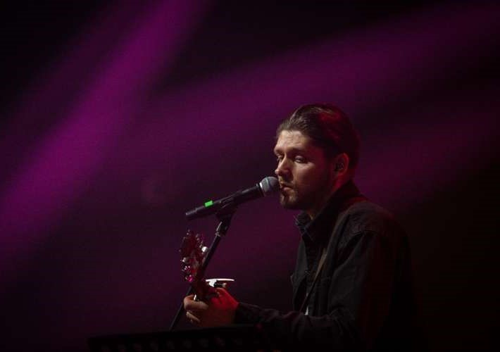 A musician stands in front of the mic